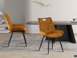 Twee elegante Eetkamerstoel 'Nina' Fluweel Goud stoelen (set van 2) met zachte goudkleurige fluwelen bekleding en zwarte metalen poten, geplaatst op een grijs vloerkleed in een moderne kamer met strak meubilair, een lichte houten vloer en een decoratieve plant.