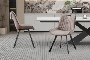 Twee Stoel 'Pablo' Micro fiber PU Grijs stoelen (set van 2) met zwarte poten staan op een grijs vloerkleed met structuur in een eigentijdse eetkamer met een witte tafel, moderne kasten, decoraccenten en een marmeren achterwand.
