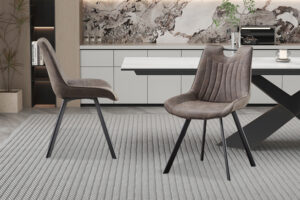 Twee Stoel 'Pablo' Micro fiber PU Donkergrijs stoelen (set van 2) met zwarte poten staan op een grijs vloerkleed met structuur in een moderne eetkamer met een marmeren accentmuur en een strakke witte tafel.