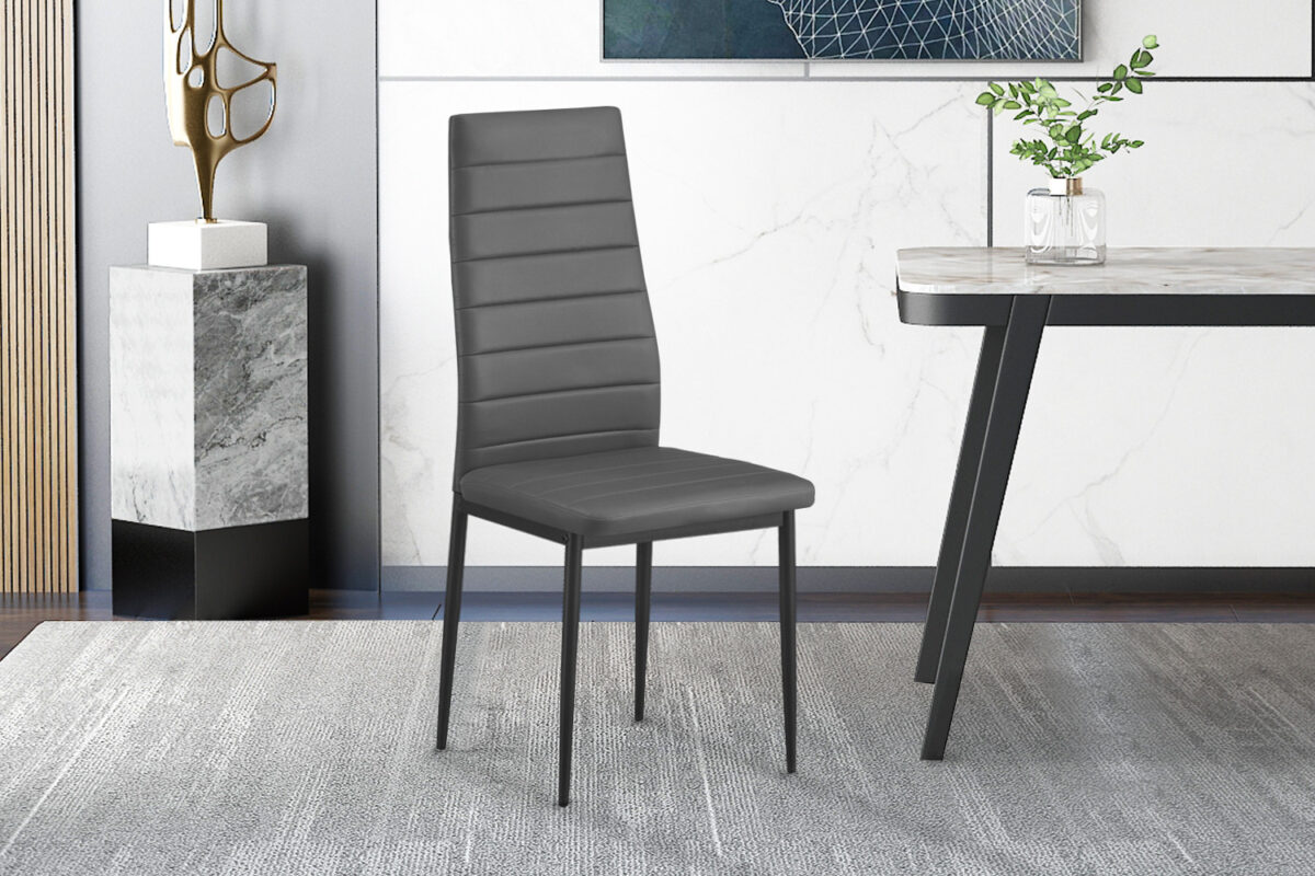 Een set van 4 'Cato/Kenzo' PU Grijs eetkamerstoelen met hoge rug en zwarte poten staat op een grijs vloerkleed in een stijlvolle kamer met marmeren en houten accenten; een deel van een tafel en decor is zichtbaar.