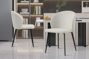 Twee moderne Stoel 'Toledo' Stof Beige stoelen (set van 2) met zwarte poten staan in een strakke minimalistische keuken met marmeren vloeren, ingebouwde planken met boeken en stijlvolle keukenbladen op de achtergrond.