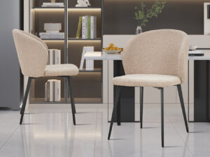 Twee Stoel 'Toledo' Bouclé Zand stoelen (set van 2) met zwarte metalen poten staan in een moderne keuken, aangevuld met ingebouwde planken, boeken, decor, een fruittoonbank en strakke eigentijdse details.