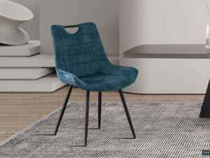 De Stoel 'Nina' Fluweel Petrol, met pluche blauw fluweel en zwarte metalen poten, staat op een grijs gedessineerd vloerkleed naast een strakke tafel in een minimalistische, eigentijdse kamer. (Verkocht als set van 2 per doos.).