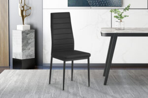 Een set van 4 'Cato/Kenzo' PU zwarte stoelen met hoge rugleuning staat op een lichtgrijs vloerkleed in een stijlvolle kamer met marmeren en houten accenten, naast een tafel met een plant in een glazen vaas.