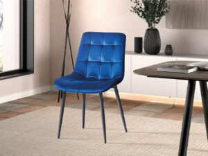 Een moderne eetkamer toont de Stoel 'Juta' Fluweel Blauw (2 per doos) met zwarte poten op een beige gedessineerd tapijt, naast een houten tafel en minimalistisch decor, tegen lichte muren en een groot raam.