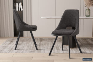 Twee 'Filou' Bouclé Grijs eetkamerstoelen met lichtgrijze PU rug (set van 2) staan op een licht gedessineerd vloerkleed in een moderne eethoek met lichthouten vloeren en een strakke tafel. Het Rousseau logo staat rechtsonder.