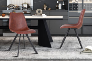 Twee Stoel 'Emma' PU Donkerbruin stoelen (set van 2) met zwart metalen poten staan rond een moderne eettafel in een eigentijdse keuken met grijze kasten, marmeren achterwand en decoratieve items op de oppervlakken.