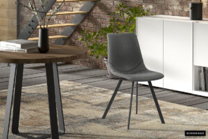 Een moderne woonruimte met twee Stoel 'Oslo' PU Zwart stoelen, een ronde houten tafel met een donkere vaas, een vloerkleed met patroon, een witte kast, een kamerplant en een bakstenen muur met een metalen trap.