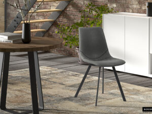 Een moderne woonruimte met twee Stoel 'Oslo' PU Zwart stoelen, een ronde houten tafel met een donkere vaas, een vloerkleed met patroon, een witte kast, een kamerplant en een bakstenen muur met een metalen trap.