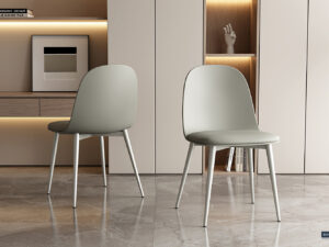 Twee Stoel 'Jasmin' stoelen met grijsgroene PP zittingen en PU kussens (2 per doos) staan op een gepolijste vloer in een stijlvolle kamer met neutrale kasten, open planken en een moderne inrichting.