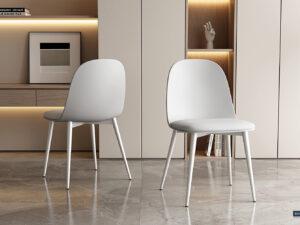 Twee Stoel 'Jasmin' stoelen met witte PP zittingen en PU kussens (set van 2) hebben afgeronde rugleuningen en staan op een glanzende marmeren vloer in een minimalistische kamer, met ingebouwde planken met boeken, kunst en een handsculptuur erachter.