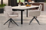 Twee Stoel 'Sevilla' Stof Beige stoelen (set van 2) met zwarte poten omringen een moderne eettafel met marmeren blad in een eigentijdse keuken. Een schaal met sinaasappels siert het tafelblad.