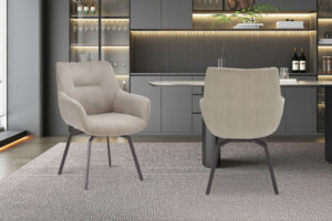 Een paar 'Modest' beige geribbelde bureaustoelen staan in een moderne keuken met grijze kasten, open schappen, verlichting onder de kasten en een grijs vloerkleed met structuur.