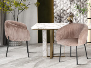 Twee moderne, gebogen Stoel 'Sevilla' Corduroy Fabb Hyper 38 Zand stoelen staan naast een wit marmeren eettafel met gouden accenten in een elegante kamer met gestructureerde muren, planten en decoratieve kunst.