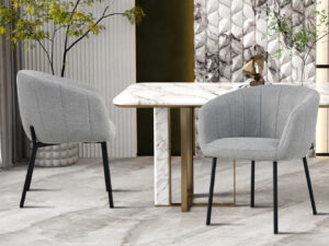 Twee Stoel 'Sevilla' Stof Lichtgrijs stoelen staan bij een wit marmeren tafel met gouden accenten in een stijlvolle kamer met gedessineerde muren, decoratieve planten en een neutrale vloer.