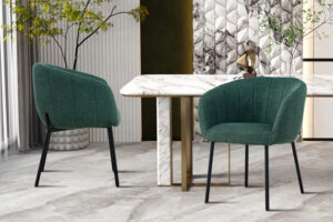 Twee Stoel 'Sevilla' Stof Groen stoelen met zwarte poten staan naast een wit marmeren tafel met gouden en marmeren steunen in een moderne kamer met grijs marmeren vloeren, kamerplanten met bladeren en wandpanelen met marmerdessin.