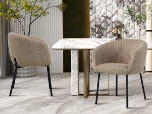 Twee Stoel 'Sevilla' Stof Zand stoelen (set van 2) met zwarte poten zijn geplaatst rond een wit marmeren eettafel met messing accenten in een moderne kamer met gestructureerde muren, planten en decoratieve sculpturen.