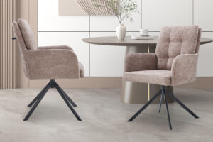 Twee 'Granada' draaistoelen bekleed met de stof Davis Bliss 75-18 Sand staan bij een ronde tafel met een vaas en theekopje, in een moderne, minimalistische kamer met lichte vloeren en wandpanelen.