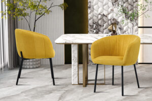 Twee Stoel 'Sevilla' Stof Geel stoelen (set van 2) met zwarte poten staan bij een wit marmeren eettafel, stijlvol gedekt met planten en wandpanelen met structuur in een modern interieur.