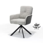 De Fred Eetkamerstoel in Stof Ecru+Cowboy 104 heeft een gewatteerde zitting en rugleuning, een zwarte 180 graden draaibare voet met automatische terugloop en een modern design.