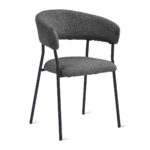 De Eetkamerstoel Ava heeft een gebogen rugleuning en een zitting bekleed met bouclé antraciet stof, ondersteund door slanke zwarte metalen poten voor een moderne look.