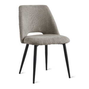 De Eetkamerstoel Monta - Taupe is een moderne eetkamerstoel met een zitting en rugleuning van beige structuurstof, een kleine uitsparing in de onderrug en vier slanke poten van zwart metaal.
