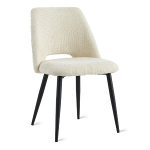 De Eetkamerstoel Monta - Beige is een moderne eetkamerstoel met een gebogen, beige gestoffeerde zitting en rugleuning, voorzien van vier schuin geplaatste, zwarte metalen poten.