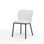 De Kim stoel Stof Teddy Ivory heeft een witte, gestoffeerde zitting en rugleuning met vier slanke, zwarte metalen poten, afgebeeld tegen een effen witte achtergrond.