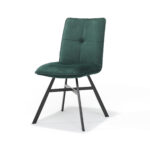De Stoel Ramon zwart - Stof Velours Groen is een moderne stoel met een groene, met velours beklede zitting en rugleuning met gecapitonneerd design en schuin geplaatste, zwarte metalen poten, afgebeeld tegen een witte achtergrond.