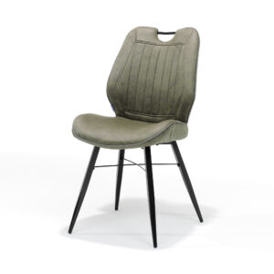 De Stoel Quattro zwart stof Soft Groen is een moderne eetkamerstoel met een licht olijfgroene, gestoffeerde zitting en rugleuning, verticale stiksels, een uitsparing in het bovenblad en slanke, zwarte, metalen poten die naar buiten staan.