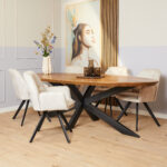 Een moderne eetkamer met een houten ovale tafel, vier Eetkamerstoel Nova Champagne stoelen met zwarte poten, een bloemenvaas en een groot vrouwenportret aan de muur. Een licht houten vloer en neutrale muren maken de look compleet.