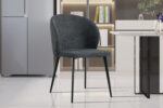 De Stoel 'Toledo' Stof Donkergrijs (2 per doos) heeft donkergrijze bekleding en zwarte metalen poten, perfect voor moderne keukens of eetkamers met glanzend witte tegelvloeren, planken en een tafel in de buurt.