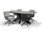 Een moderne eettafel met een rechthoekig, donkergrijs blad en zwart geometrisch onderstel wordt omringd door vier Fred Eetkamerstoel stoelen in Stof Ecru+Cowboy 104 stof, elk met armleuningen en zwarte 180° draaibare metalen poten.