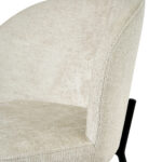 Close-up van Eetkamerstoel Lio - Beige, met beige bekleding, een gebogen rugleuning en stevige zwarte metalen poten.