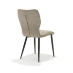 De Stoel Roma - M3 Zwart Stof Soft Pebble is een moderne stoel met een beige gestoffeerde zitting en rugleuning, zwarte slanke metalen poten, afgebeeld vanuit een hoek op de achterkant tegen een witte achtergrond.