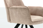 Close-up van de Eetkamerstoel Nova Beige, een moderne beige gestoffeerde fauteuil met een zachte, fluweelachtige textuur en schuine zwarte poten tegen een witte achtergrond.