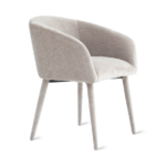 De Eetkamerstoel Nova - Beige is een moderne gestoffeerde fauteuil met een lichtbeige afwerking, een gebogen rugleuning en vier taps toelopende poten, geïsoleerd afgebeeld op een witte achtergrond.