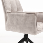 Een close-up van de Eetkamerstoel Dani | Velvet Champagne (set van 2), met moderne fluwelen bekleding en een stijlvolle zwarte draaivoet tegen een witte achtergrond.