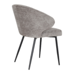 De Eetkamerstoel Pete - Stof Antraciet heeft een modern ontwerp met antraciet stof, een gebogen rugleuning en slanke zwarte metalen poten, schuin van achteren afgebeeld op een witte achtergrond.