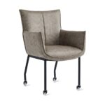 De Eetkamerstoel Thomas - Microleder Taupe is een moderne fauteuil met taupe microlederen bekleding, zwarte metalen poten en vier kleine zwenkwieltjes voor eenvoudige mobiliteit, tegen een witte achtergrond.