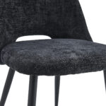 Close-up van de Eetkamerstoel Monta - Antraciet, met een gestructureerde donkergrijze stoffen zitting en rugleuning, ondersteund door slanke zwart metalen poten.