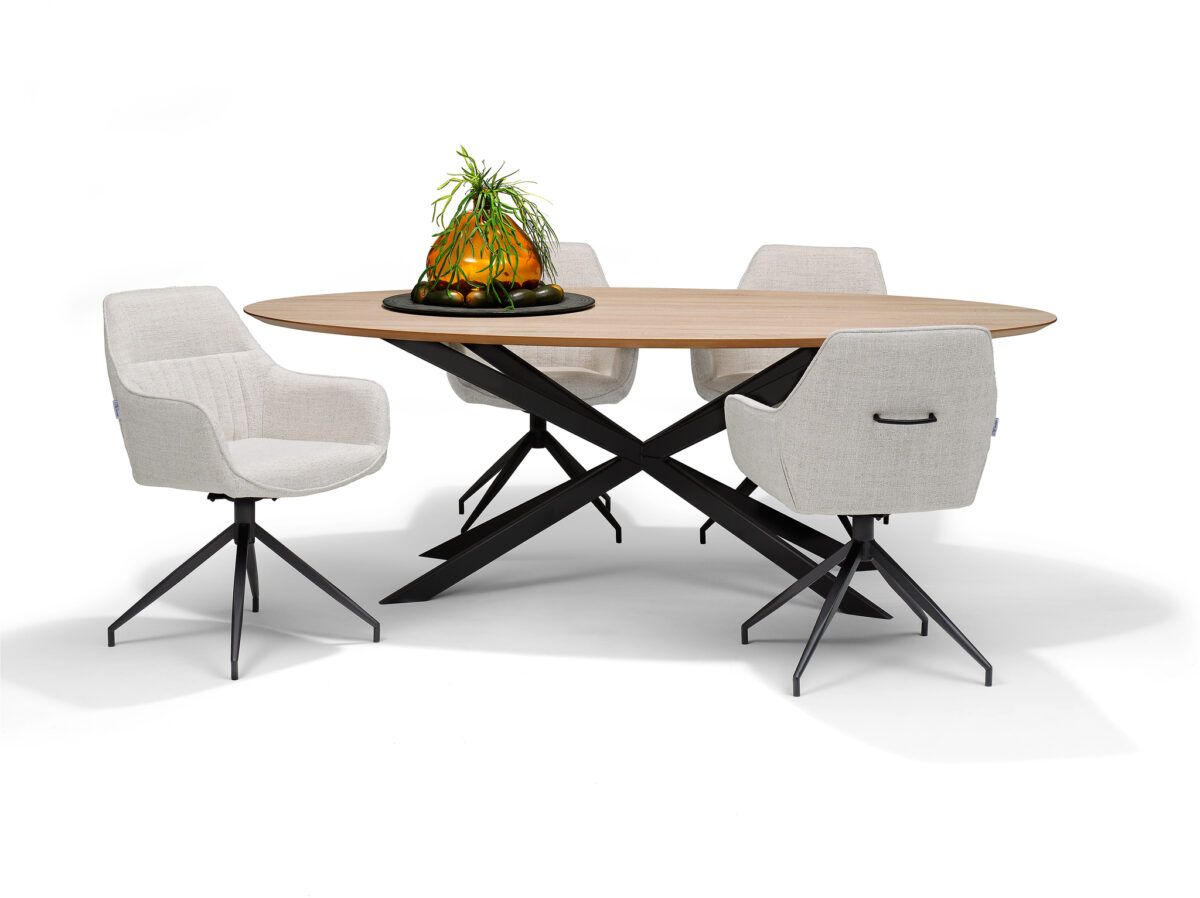 Een moderne ovale houten tafel met zwarte gekruiste poten wordt omringd door vier Toscane Eetkamerstoel - Stof Oasis Natural - draaivoet M4 draaistoelen, met een glazen schaal met een plant als middelpunt.