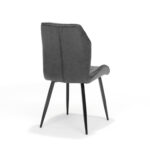 De Stoel Girona zwart Stof Soft Antraciet is een moderne stoel met een donkergrijze gecapitonneerde rugleuning en zitting, slanke zwarte metalen poten en is afgebeeld op een witte achtergrond die iets schuin van de rug staat.