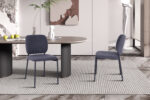 Moderne kantoorruimte met twee PROMO - Stoel 'Sophia' Stof Donkergrijs stoelen rond een ovale tafel, een plant in een glazen vaas en een minimalistische inrichting met abstracte kunst en een wit beeld op de achtergrond.