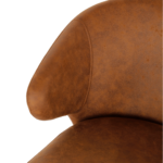 Close-up van de Eetkamerstoel Pete - Microleder Cognac, met de nadruk op de armleuning, rugleuning en zitting met zichtbare stiksels en een glad, licht gestructureerd oppervlak van microleder.