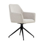 De Eetkamerstoel Tess Linnen Beige is een moderne fauteuil met lichtbeige stof, schuine armleuningen en een zwarte vierpoots metalen draaivoet, tegen een witte achtergrond.