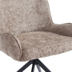 Close-up van de Eetkamerstoel Lily - Taupe met lichtbruine stoffen bekleding en zwarte metalen poten, die de zitting, rugleuning en een deel van de armleuningen accentueren.