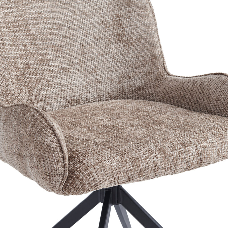 Close-up van de Eetkamerstoel Lily - Taupe met lichtbruine stoffen bekleding en zwarte metalen poten, die de zitting, rugleuning en een deel van de armleuningen accentueren.