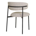 De Dining chair, bouclé, zand met zwarte poten, HN1267 (set van 2), heeft een afgeronde beige stoffen zitting en rugleuning op een strak zwart metalen frame met vier rechte poten, schuin van achteren afgebeeld.