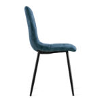 De Eetkamerstoel Yerevan Velvet Petrol is een moderne stoel met een blauw fluwelen, getufte rugleuning en zitting, in profiel gezien, met slanke, schuine zwart metalen poten.